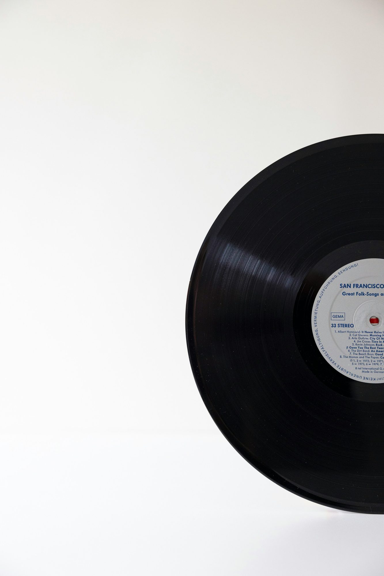 A vinyl record photographed on a soft ivory background